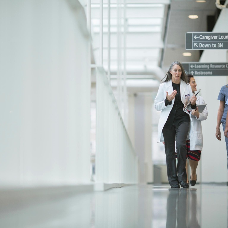 Healthcare workers walk in a hospital corridor