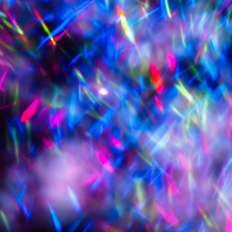 Colorful lights blurred glitter background. Abstract illuminated texture. Christmas, new year or birthday celebration. Night life photography. Blue and purple neon colors overlay. Space for text.