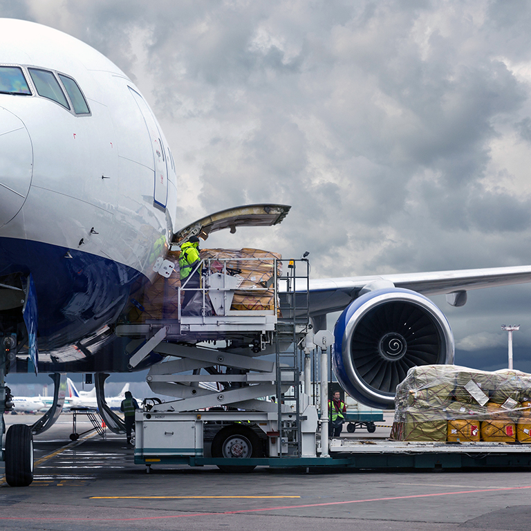 Loading cargo on the plane in airport, view through window