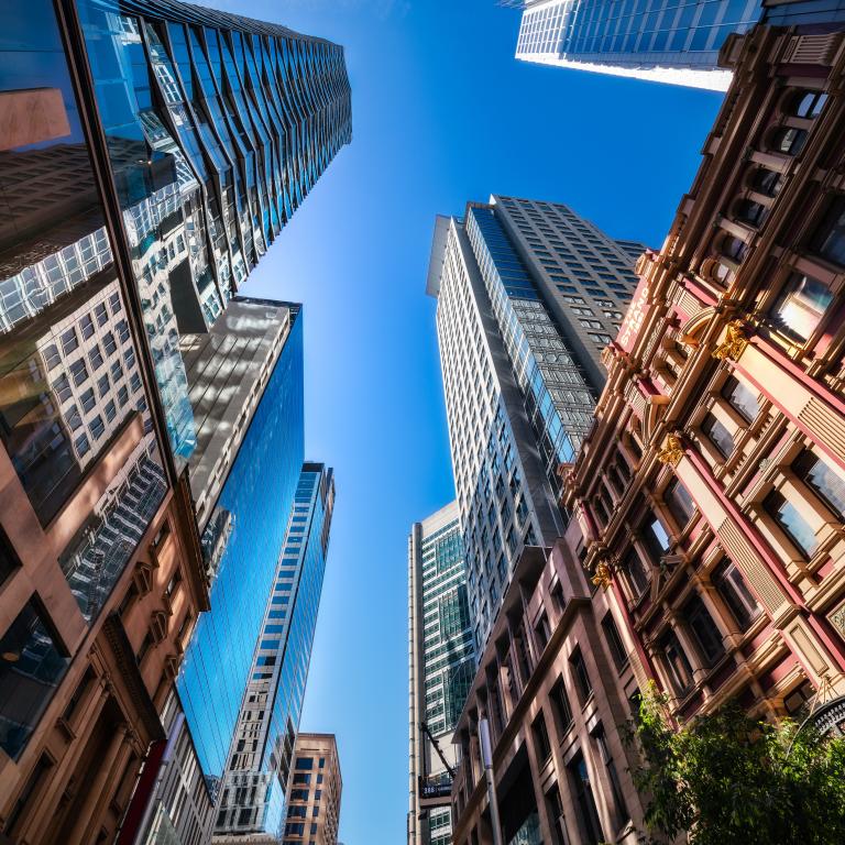 Looking up at tall buildings in a city on a clear day