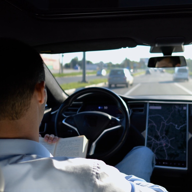 Male businessperson reading book during riding on electrical vehicle