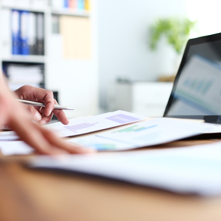 Workflow focus in a modern office setting with documents and laptop