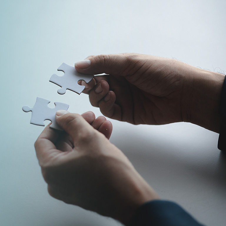 Man holding two jigsaw puzzles put together, business management concept and business risk management. Business solutions, success and strategy concept.