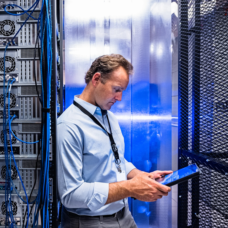 Man looking at a tablet in a server room