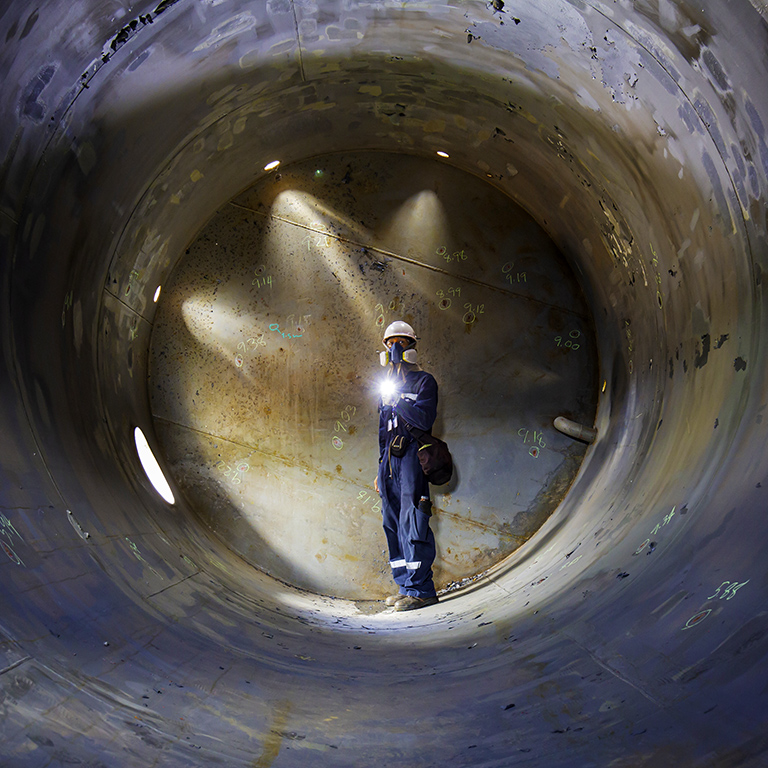 Working male inspection weld underground of tank equipment tunnel By using the flashlight in side confined.