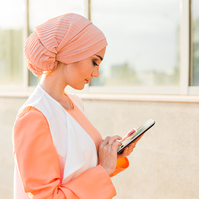 Portrait of Arab businesswoman holding a tablet. The woman is dressed in an abaya