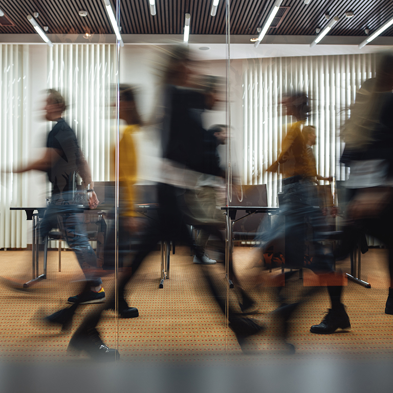 Motion blur group of people walking in office