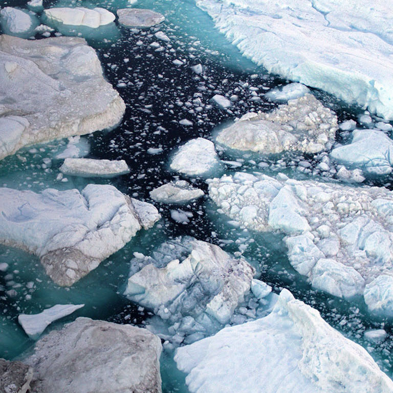 Global Warming and Climate Change - Icebergs from melting glacier in icefjord in Ilulissat, Greenland. Aerial photo of arctic nature iceberg and ice landscape. Unesco World Heritage Site.