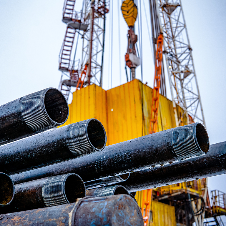 Oil Drill pipe. Rusty drill pipes were drilled in the well section. Downhole drilling rig. Laying the pipe on the deck. View of the shell of drill pipes laid in courtyard of the oil and gas warehouse.