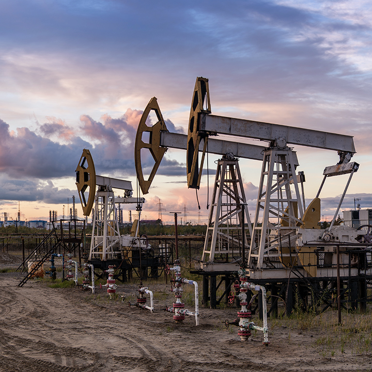 Panoramic of a pumpjack and oil refinery.