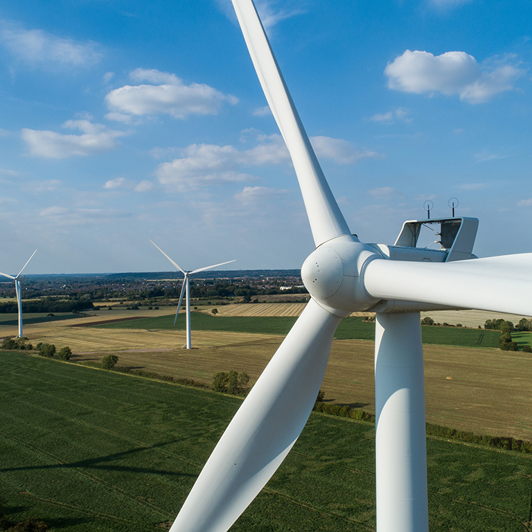 Close-up of Wind Turbine - Windfarm in Horizon