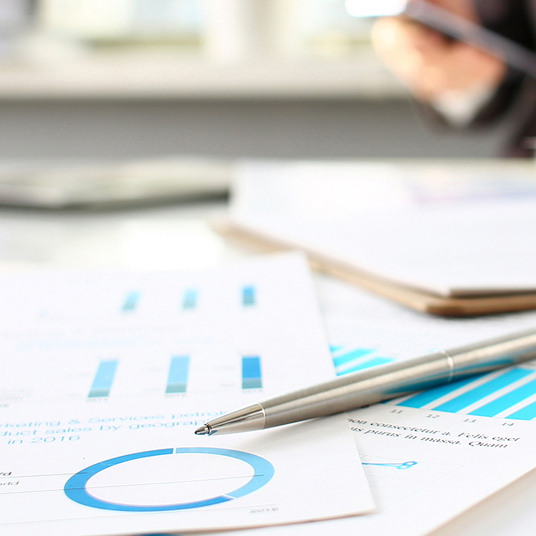 Silver pen lie on paper with analytics on table in office