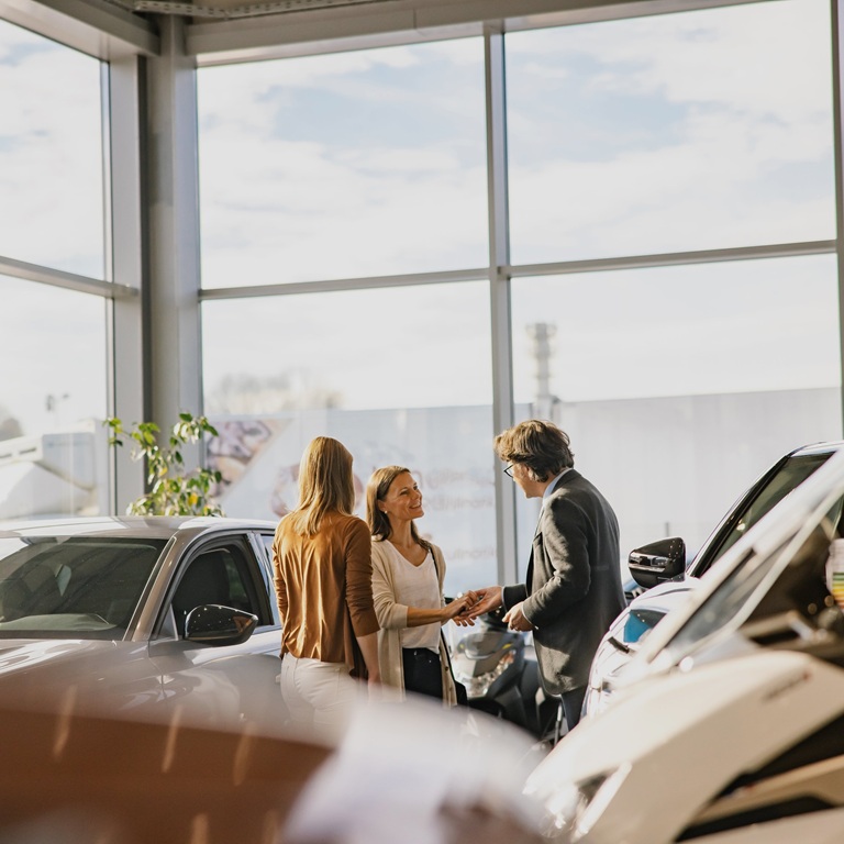 People discussing cars in a dealership