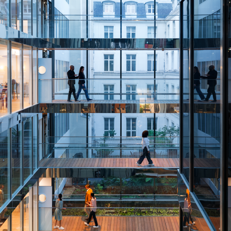People walking in a modern building with glass walls