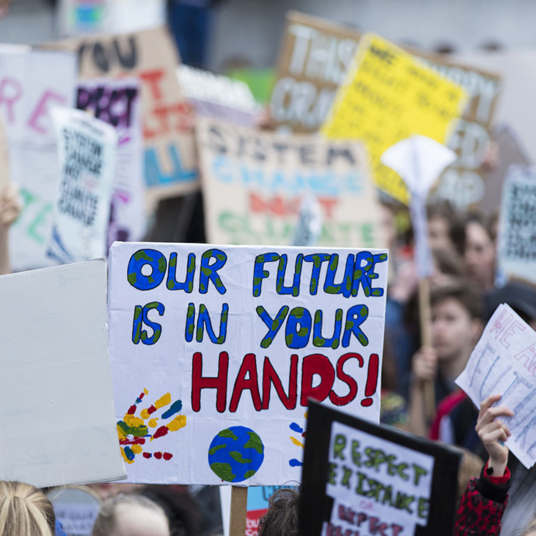 People with banners protest as part of a climate change march