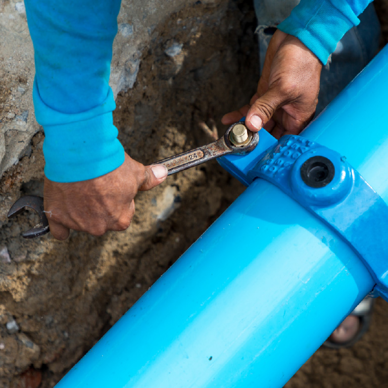 Person using a wrench on water pipes