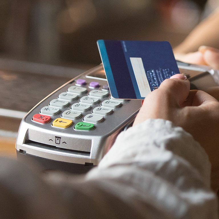 Female customer holding credit card near nfc technology on counter