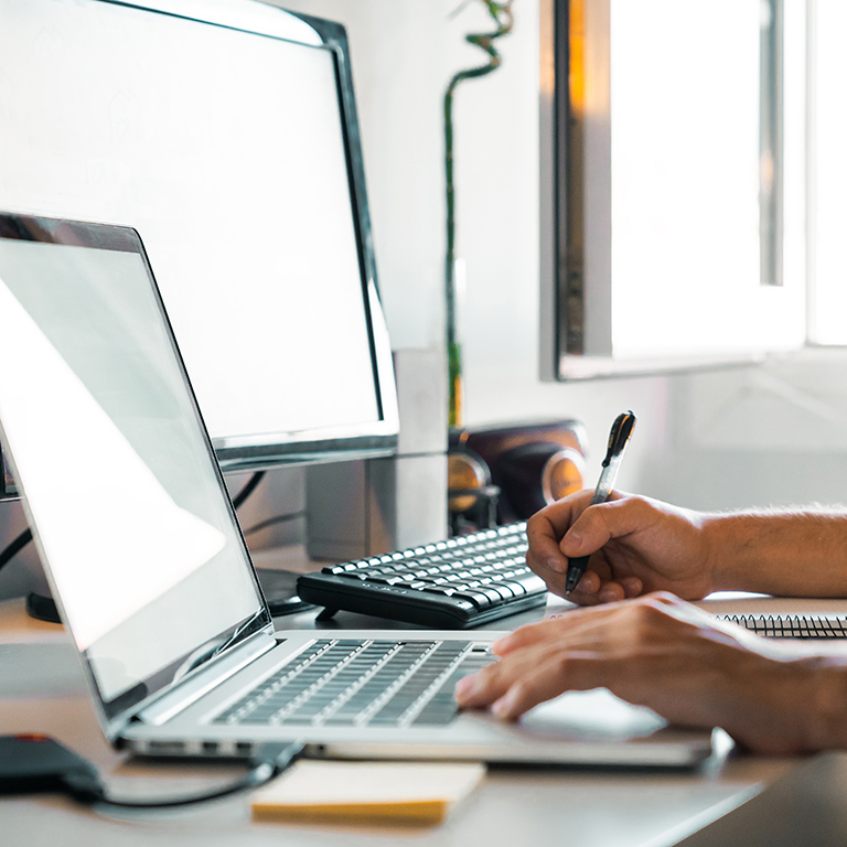 Person working from home at their desk with computers