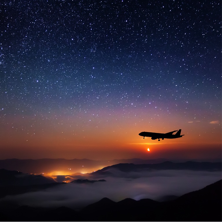 plane soars through a vibrant sunset sky