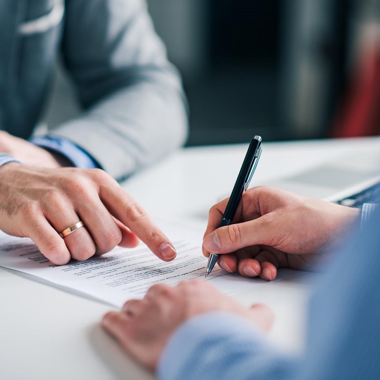 Businessmen hand's pointing where to sign a contract, legal papers or application form.