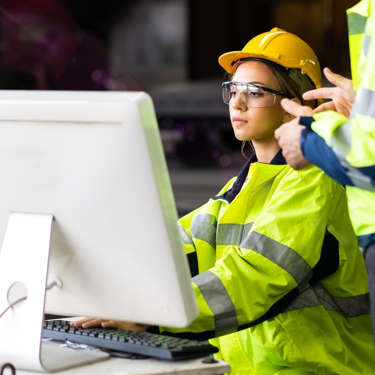 Engineer man and woman worker working on Personal computer in Heavy Industry Manufacturing Facility. Professional engineering team.