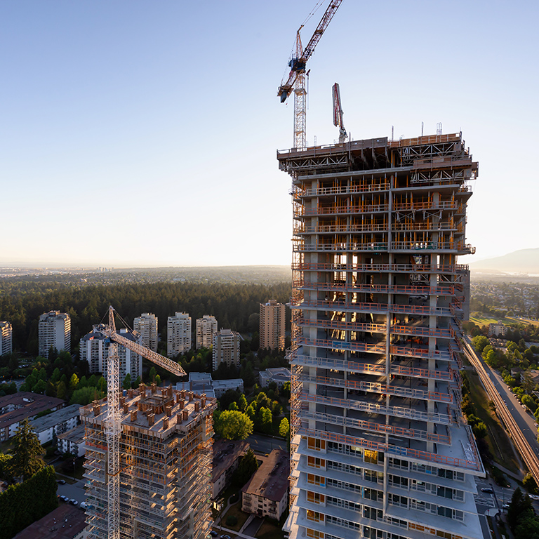 Aerial view of a residential building construction site during a vibrant summer sunset. Taken in Burnaby, Vancouver, BC, Canada.