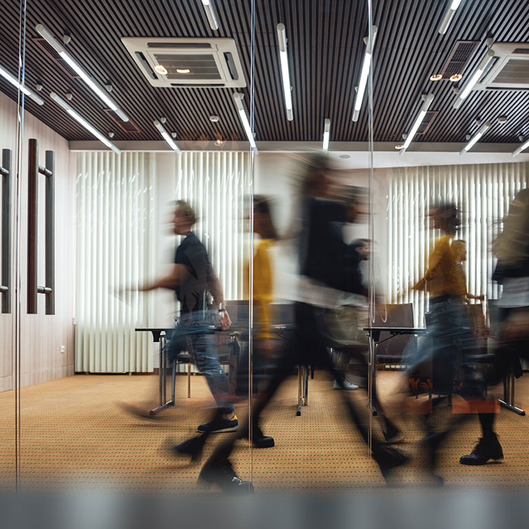 Group of office employees at coworking center. Business people walking at modern open space. Motion blur. Concept