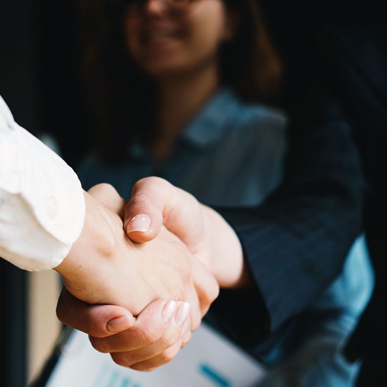 Young business people shaking hands in the office. Successful negotiations. Three persons