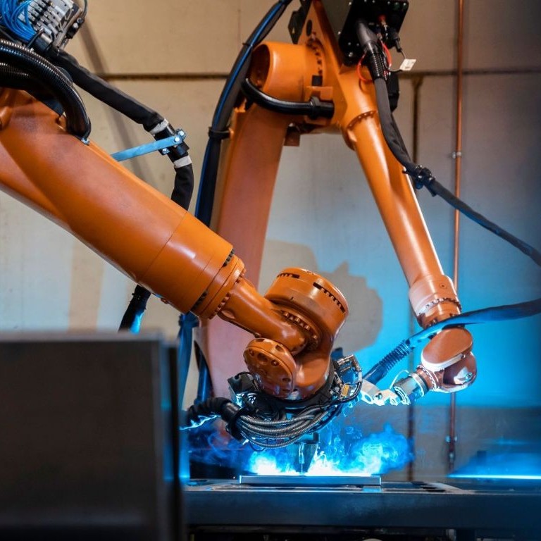 Robots welding metal in a factory setting