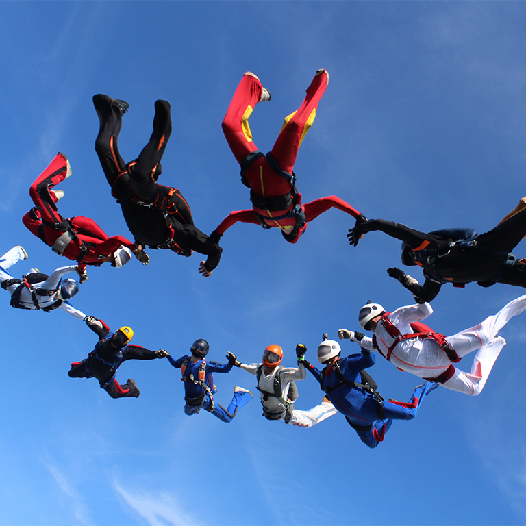 Skydiving. A circle figure of skydivers is in the sky.