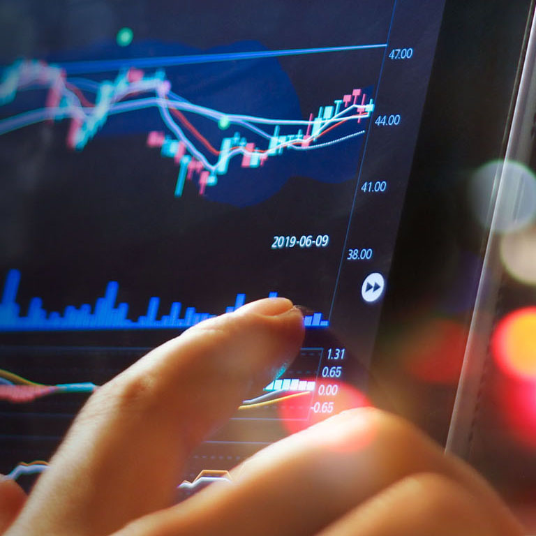 Businessman checking stock market data on tablet on night background