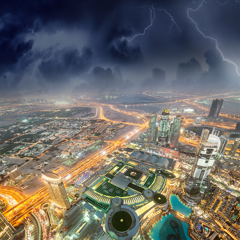 Dubai panoramic skyline and buildings at night with storm approaching.