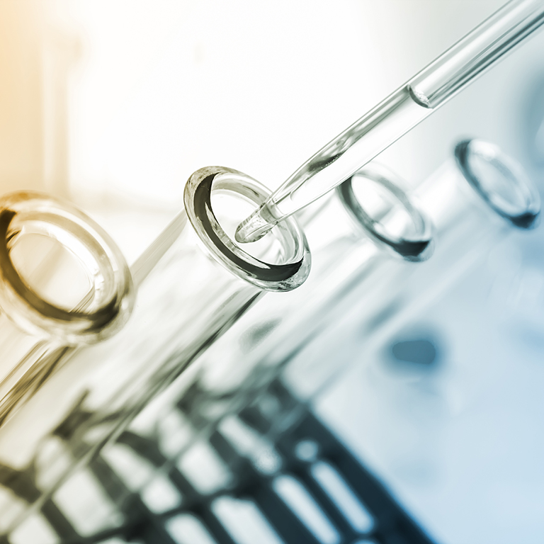 Test tubes closeup. medical glassware pipette and test tube on coloured background