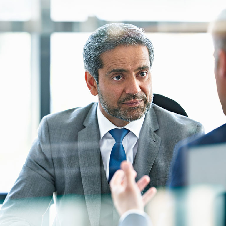 Two professional business men talk transforming health systems while sitting in their office