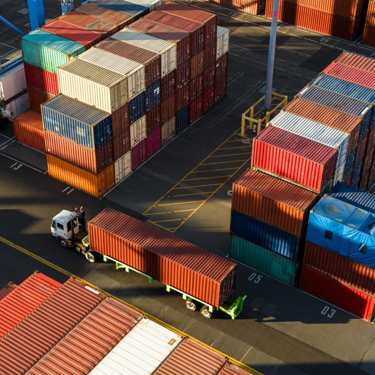 Trucks move containers in busy shipping yard
