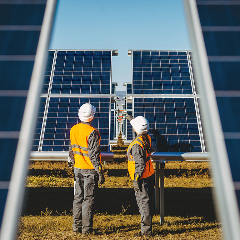 Two engineerers reviewing solar panels of a green electricity power station