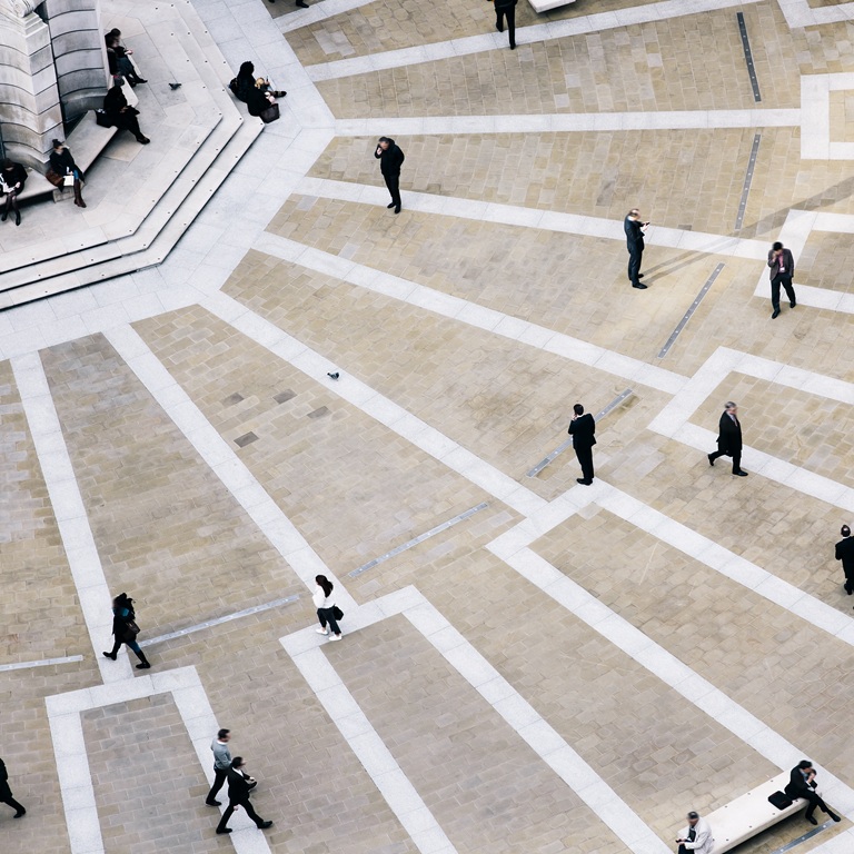 A variety of individuals are strolling in a modern plaza