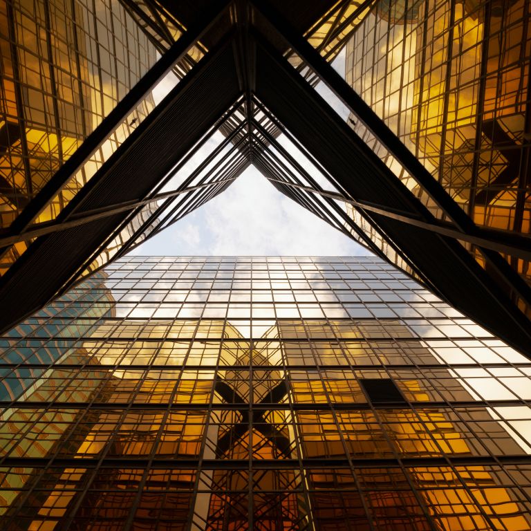Views of glass building reflecting sunlight from the sky