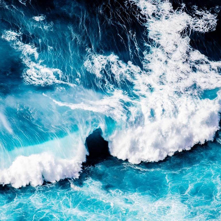 Waves crash on bright ocean