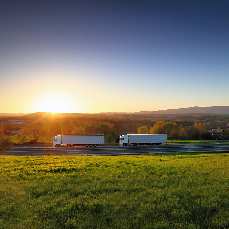 White truck transport on the road and cargo at sunset