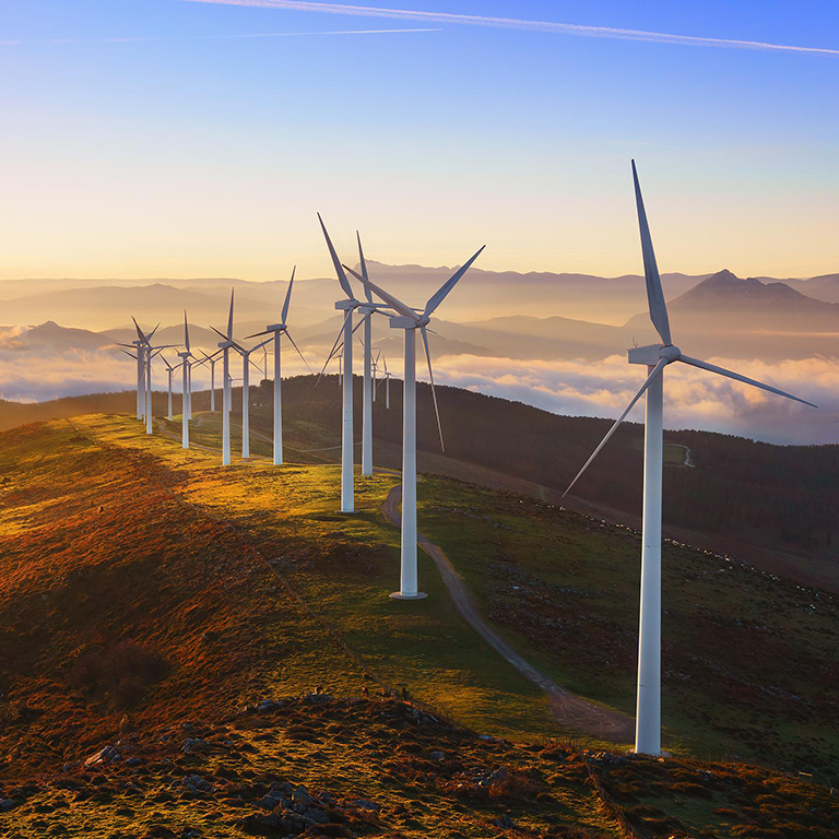 Wind turbines on top of a hill during sunset Net-zero