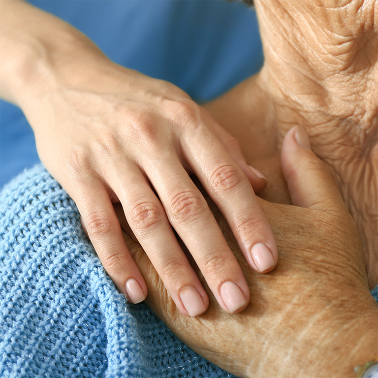 Doctor supporting elderly woman in clinic, closeup