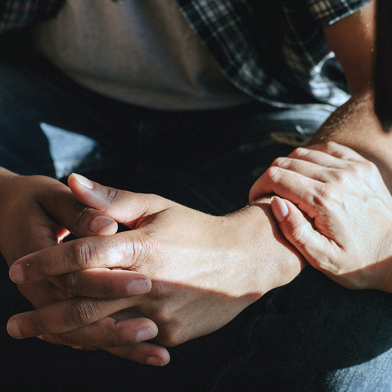 Woman consoling a man with a checkered shirt. Talk therapy. Mental health concept.