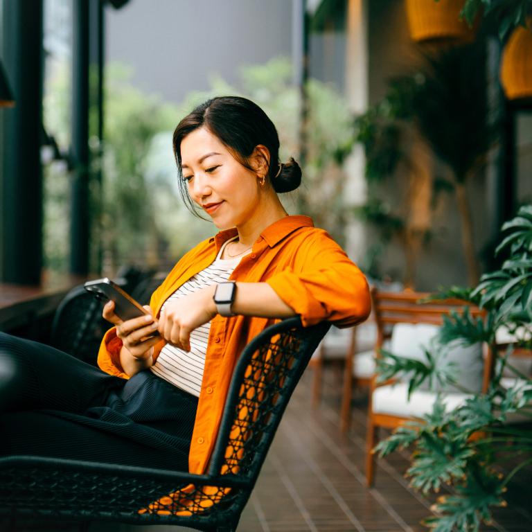 Woman enjoying time in cafe while using smartphone
