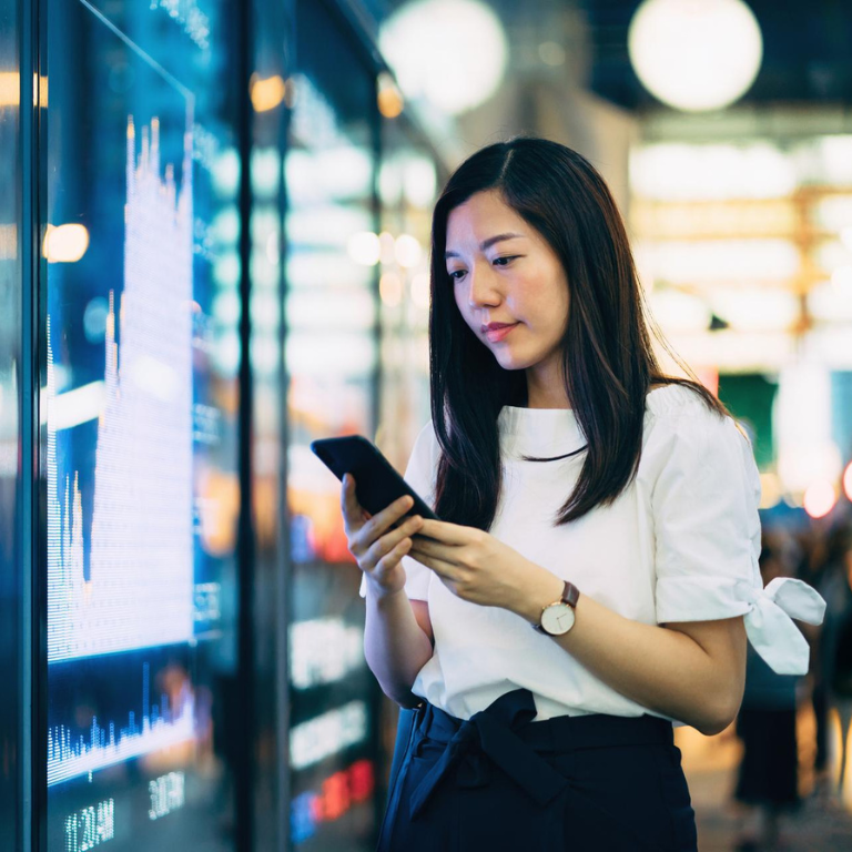 Woman looks at the phone, blurred background