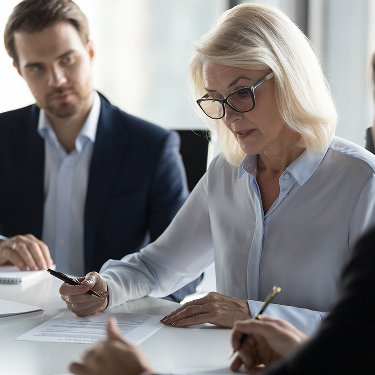 Concentrated aged businesswoman checking agreement before signin