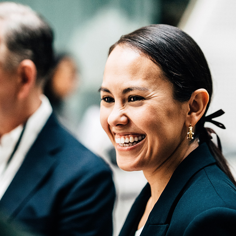 Women smiles during conversation in indoor event setting