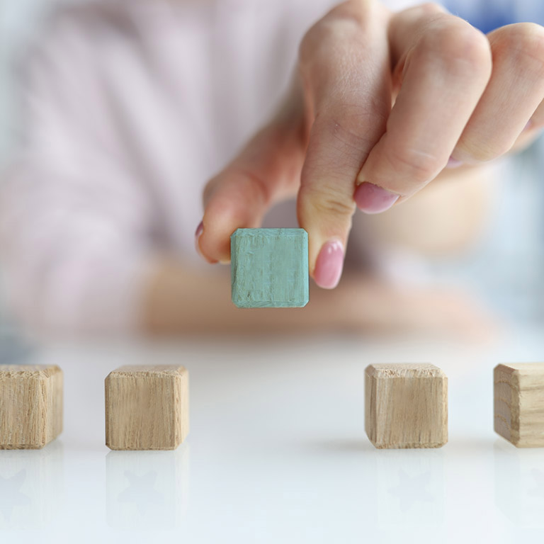 Hand holds cube made of wooden blocks in shape of five red stars. Best concept of customer experience evaluation