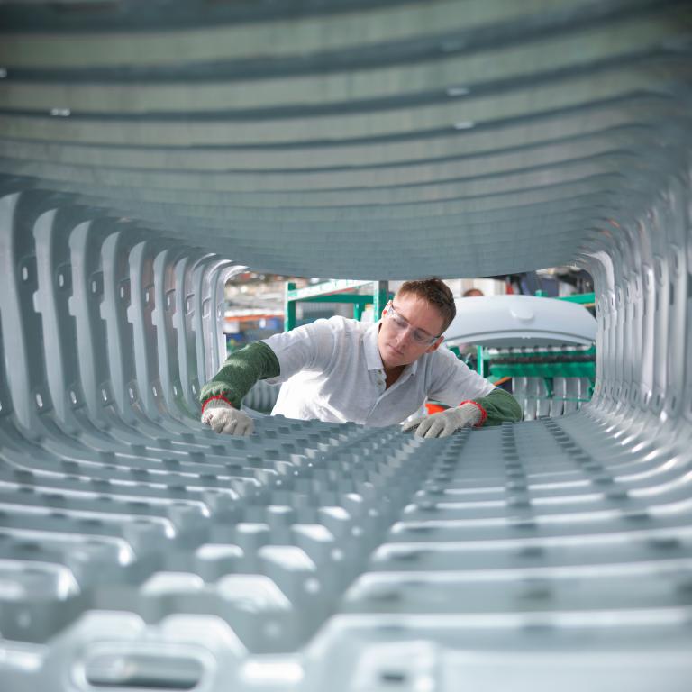 Worker examines metal parts in factory