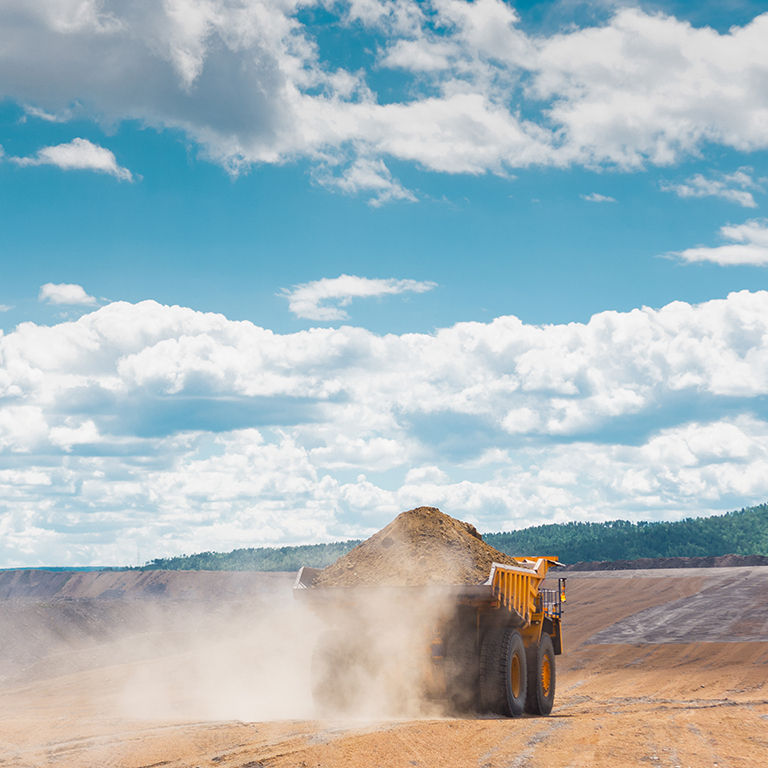 Big trucks working in an open pit. Coal mine.